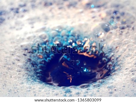 splash from the impact of a drop of colored liquid on the surface of the water