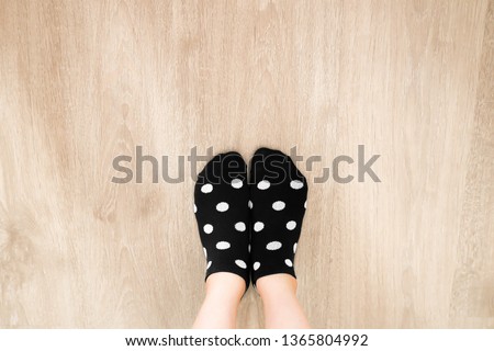 Socks White Color Dot in Black Pattern Top View. Portrait of Beautiful Young Woman Wearing Black Polka Dot Socks on Wooden Floor Background, Vintage Toning. Selfie People Legs and Feet Wear Soft Sock.