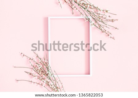 Flowers composition. White flowers, photo frame on pastel pink background. Flat lay, top view, copy space