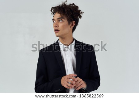 A business man looks to the side curly hair black earrings                