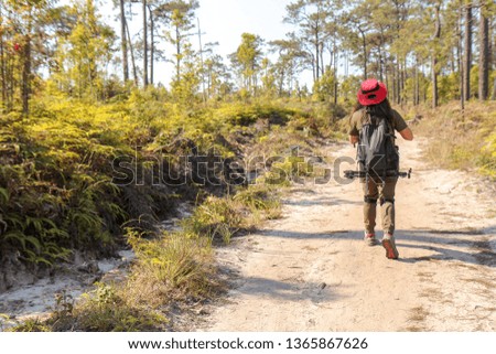 Asian woman traveler with backpack  at mountains and Tropical forest. Female photographer outdoors in nature. Travel holiday relaxation concept.