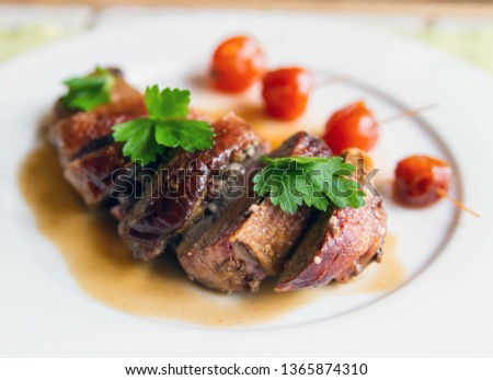 Duck roll in demi-glace sauce on a plate