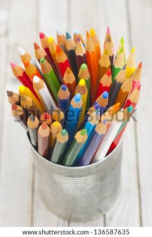 color pencils in tin can, wood table