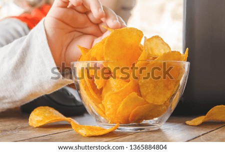 child with chips behind a computer. selective focus. nature.
