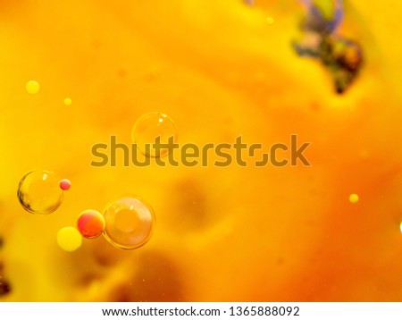 Yellow, pink and transparent spheres in abstract orange background. Close up macro shot.  