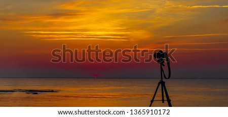 Colorful sunrise over the sea & a camera taking picture in Jeju island, Korea