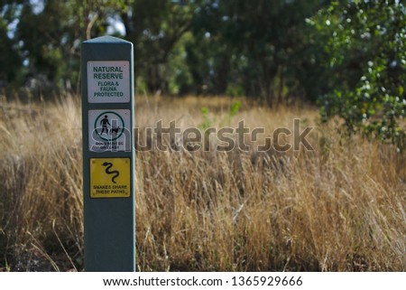 Natural Reserve, Dogs Must Be On Leash, and Snakes Share These Paths Sign