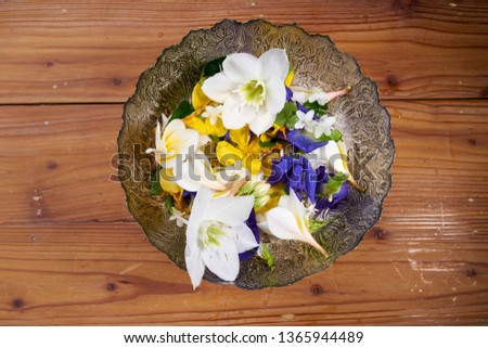 Flowers and Water in silver water bowl on wood table
