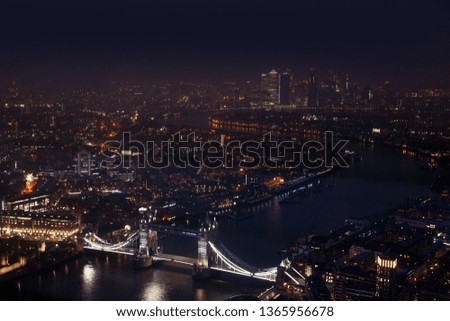 London at night with the Thames, Tower Bridge and urban architecture.