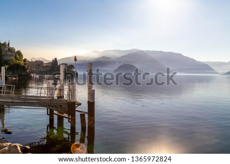 View on a wooden dock in Como Lake in front of Bellagio and the near hills. Varenna, near Milan,  Italy
