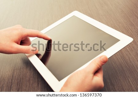 white tablet with a  blank screen in the hands 