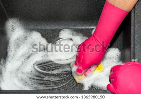 The process of washing the dark sink, hands close-up. A man in pink gloves washes a sink. Cleaning, clean up