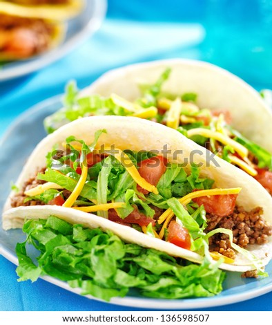 Mexican food - Soft shell tacos with beef, cheese, lettuce and tomatoes