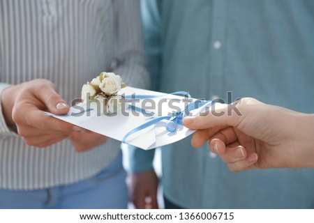 Couple receiving wedding invitation, closeup