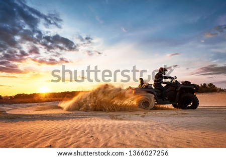Racing powerful quad bike on the difficult sand in the summer. Royalty-Free Stock Photo #1366027256