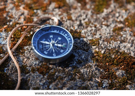 compass on mossy stone travel concept