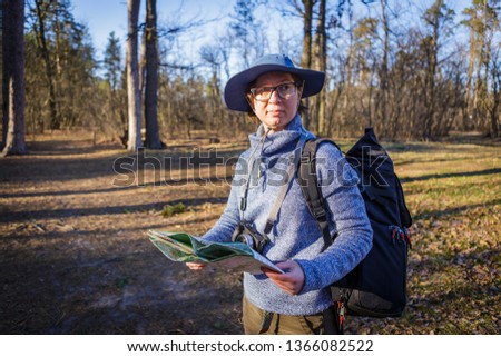 female tourist in the forest looks at a map