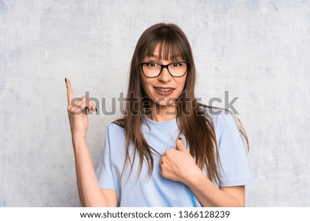 Young woman on grunge background with surprise facial expression