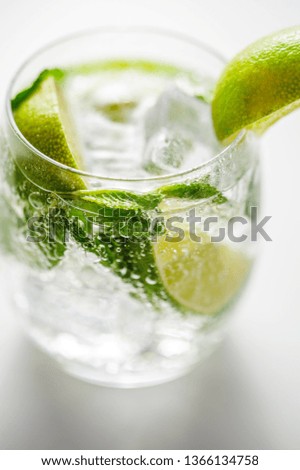 Mojito cocktail with lime, and ice  on a black board with peppermint leaves, slices of lime.