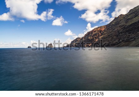 Roques de Salmor, volcanic rocks and cliff in Atlantic ocean,with blue sky and white clouds, long exposure photography, Frontera, El Hierro, Canary islands, Spain