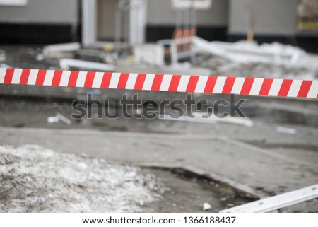 Red and white hazard tape on red and white cones