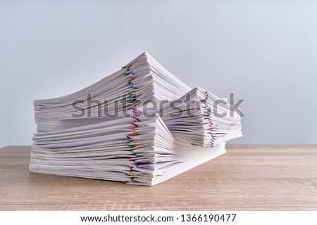 Pile overload paperwork of report of receipt with colorful paperclip place on wood table and white background with copy space. Business and finance concepts successful photography.