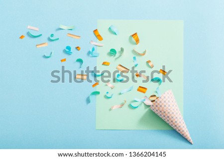 birthday hat with confetti on blue paper background