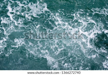 Sea water with white foam on surface, taken form top view angle.