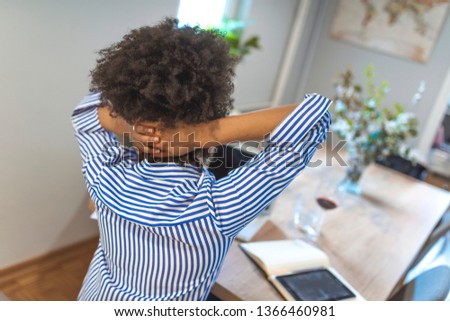 Young office worker with neck pain touching her back. Business Woman suffering from back pain. Incorrect sitting posture problems. Pain relief, chiropractic concept. Young exhausted,depressed