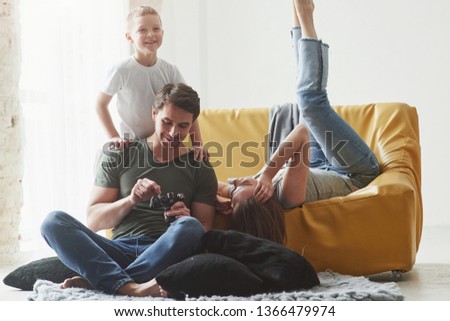 Smiling child. Young couple with kid looking together at the pictures maked by camera.
