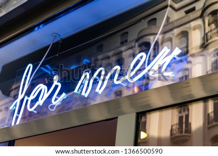 neon sign "for men" and reflection of building in a showcase