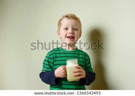 Happy smiled blond caucasian boy with green healthy vegetable detox smoothie indoor. healthy eating, vegan, vegetarian, organic and raw food and drink concept