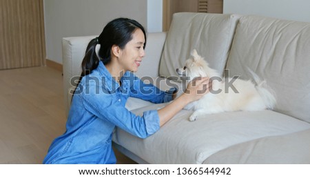 Woman cuddle her Pomeranian dog at home