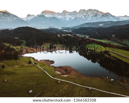 Aerial view of Geroldsee, an alpine lake and Mittenwald with Karwendel mountains in the background in autumn. Gerold, Bavaria, Germany.