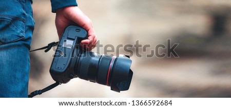 man hand with camera in autumn forest