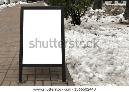 blank outdoor white board at a sidewalk near the snow. empty white Wooden menu board as a street advertising
