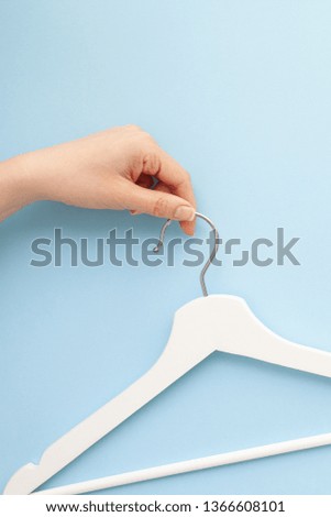 Creative top view flat lay white wooden hangers isolated pastel blue background with copy space minimalism style. Template fashion feminine blog social media sale store promo design shopping concept