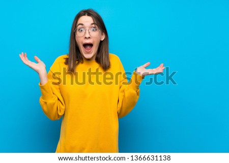 Teenager girl on isolated blue wall with shocked facial expression