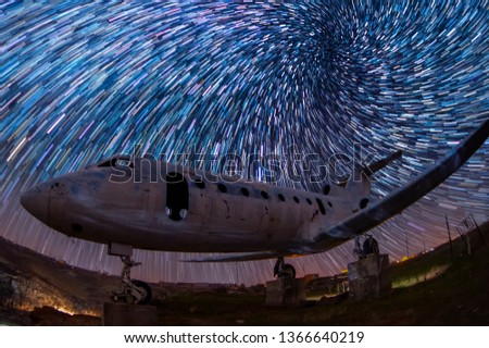 Old plane at the night and beautiful star trails background.