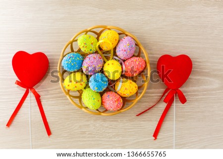Easter eggs with tulips in heart shell on blue wooden background