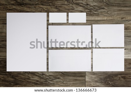 Blank corporate identity template. Package of business card envelope & letter on wood floor. 
