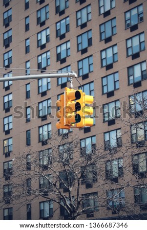 A yellow traffic light with a building background in new york street use 