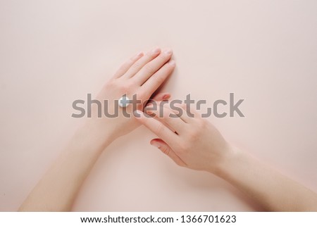Woman moisturizing her hand with cosmetic cream lotion with copy space on beige background. Concept template feminine blog, beauty concept