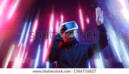 Model young man with beard in glasses of virtual reality. Augmented reality, science, future technology, people concept. VR. Futuristic 3d glasses with virtual projection. Neon light.