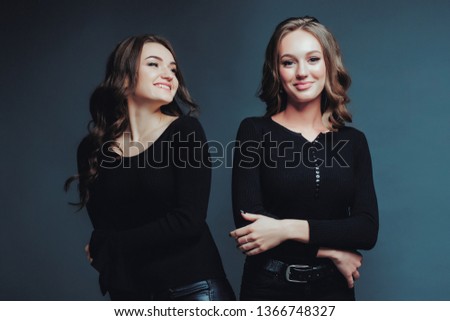 Women two smiles communication friendship evening love relationship joy black background studio. Center middle shot. Close up. Blue cyan toned photo.
