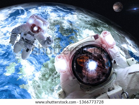 Asrtonauts in outer space near Earth and Mars planets of Solar system. Science fiction wallpaper. Elements of this image furnished by NASA