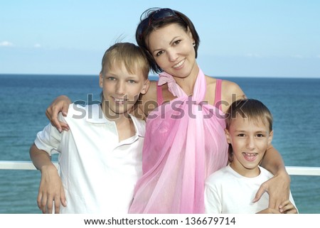 portrait of a happy mother with her sons on the background of the sea
