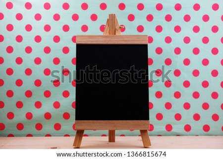 blank blackboard with easels on pink polka dot background