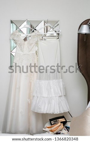Womens white dress with patterns in the shape of flowers hanging on a hanger,womens ballet flats on the coffee table. 