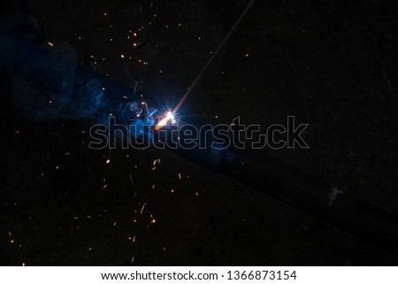 welding steel with sparks lighting in the dark background.